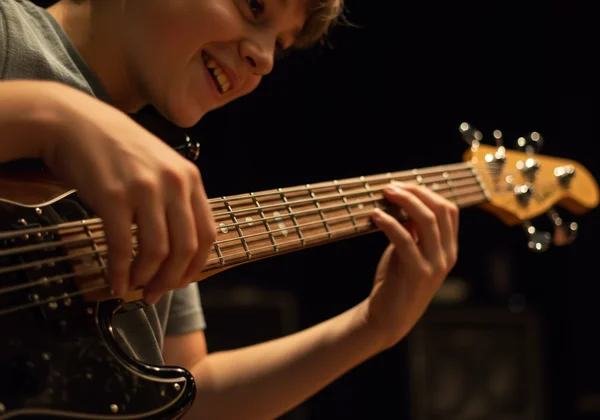 Beginner bassist playing, focused and excited