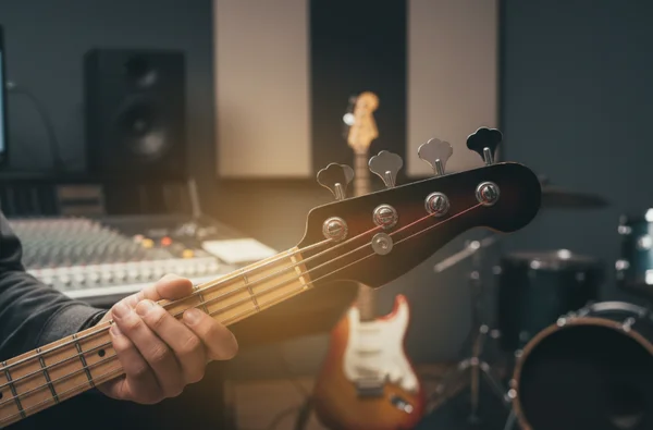 Bass guitar being tuned and adjusted